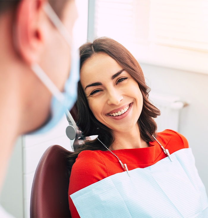 Woman in dental chair smiling at dentist