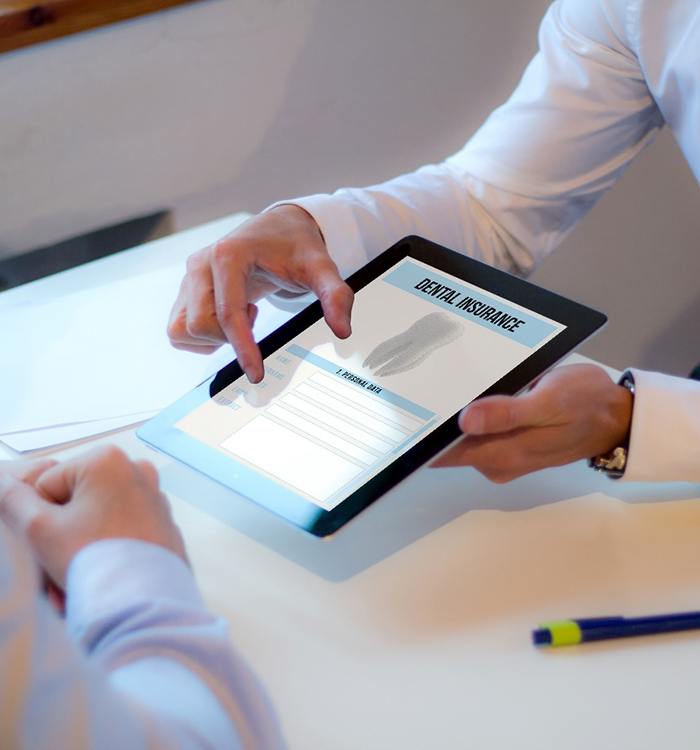 Two people looking at dental insurance forms on tablet