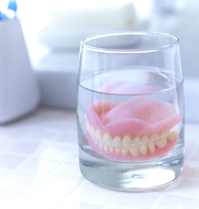 Full dentures soaking in solution