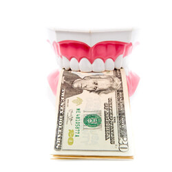dentures with dollar bills between the teeth