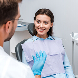 Woman in dental chair talking to her dentist