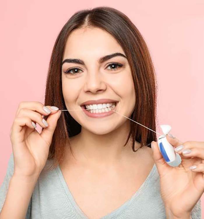 Smiling woman flossing