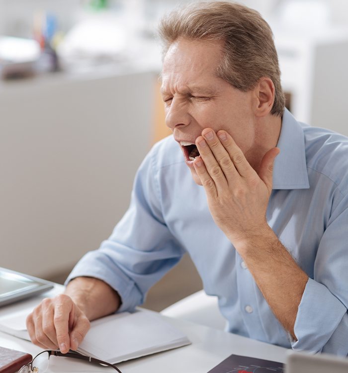 Man holding jaw in pain