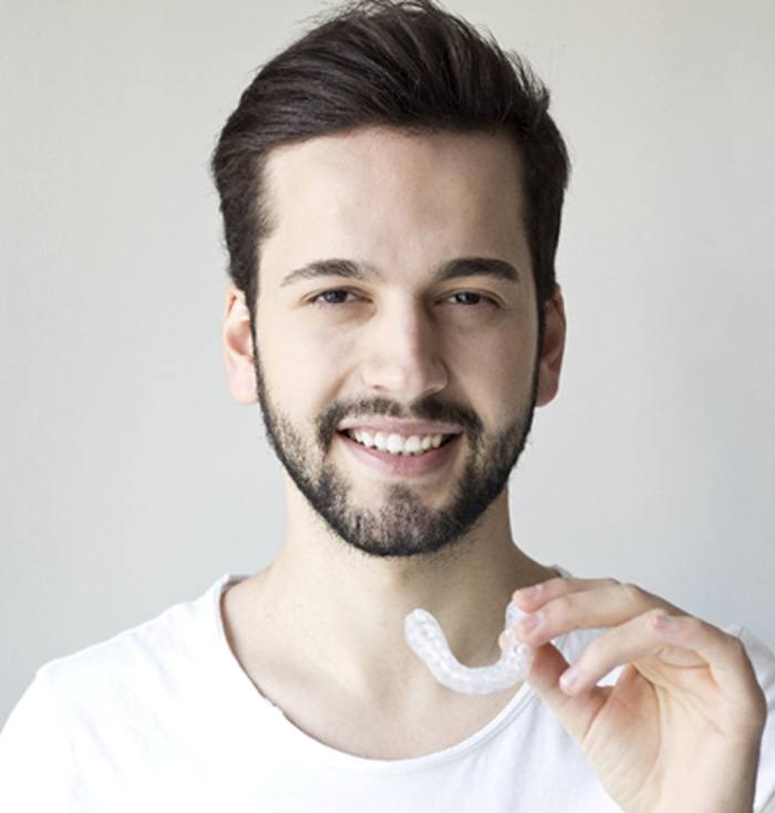 Man using custom nightguard to prevent teeth grinding