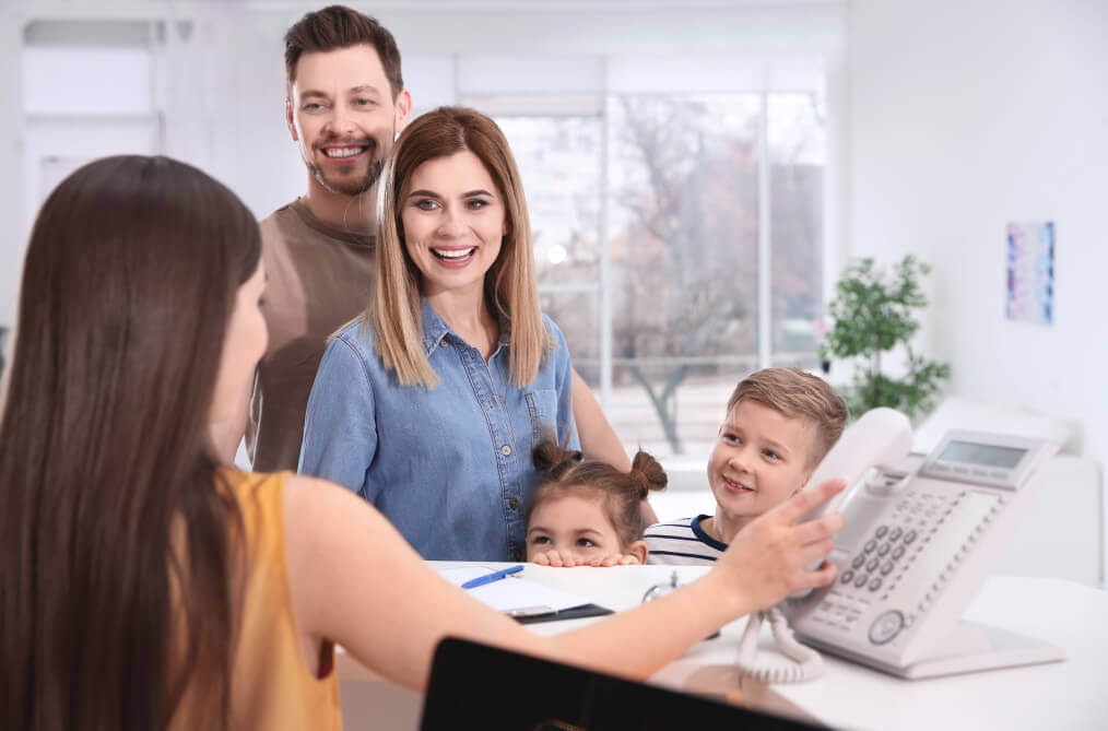 Family submitting dental insurance information at front desk