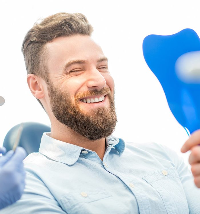 patient smiling in dental mirror