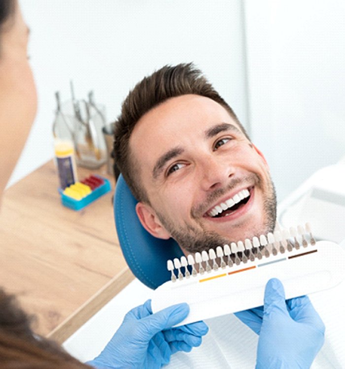 Male dental patient smiling after teeth whitening treatment