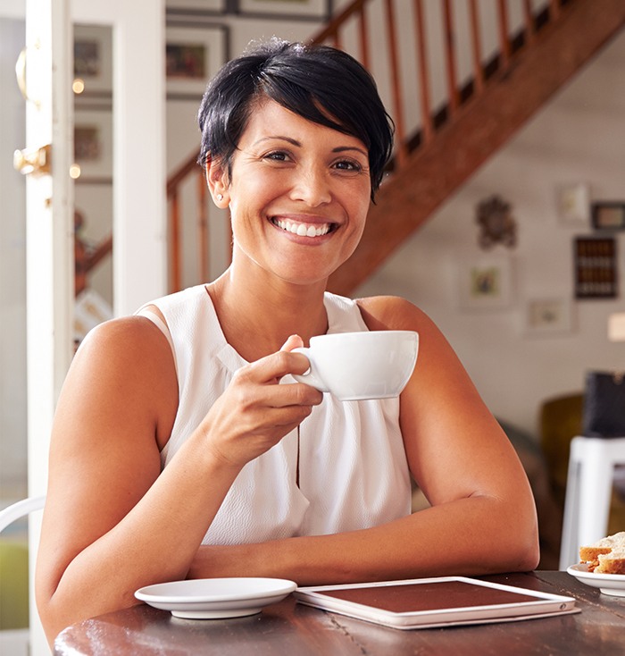 Woman smiling and holding coffee mug