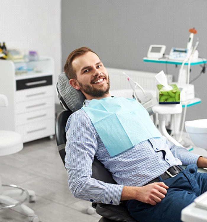 Man at dental appointment, part of caring for his veneers