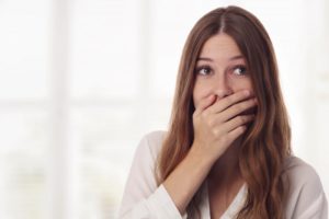 woman holding her face and experiencing a dental emergency