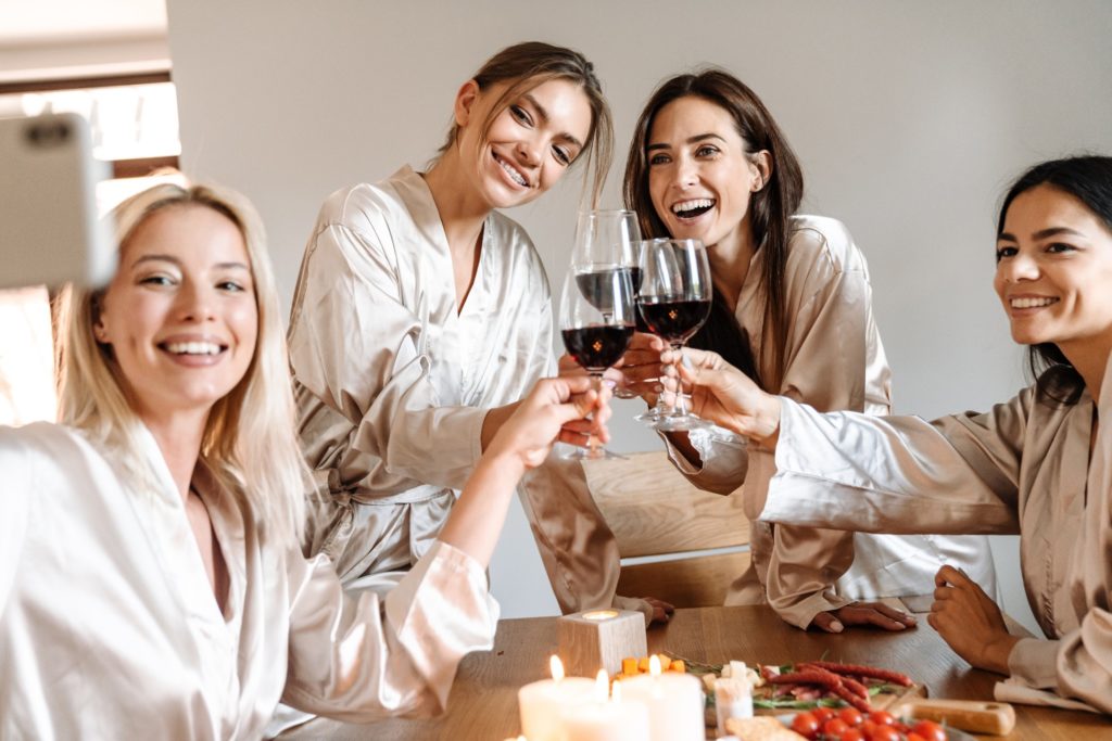 Bridesmaids taking selfie and drinking wine